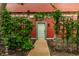 Backyard view of a door surrounded by lush landscaping, vines, and stone walkway at 1320 N New Jersey St, Indianapolis, IN 46202