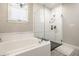 Bright bathroom featuring a soaking tub, glass-enclosed shower, and decorative chandelier at 1320 N New Jersey St, Indianapolis, IN 46202