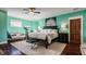 Bedroom with turquoise walls, white trim, modern ceiling fan, and dark wood furniture at 1320 N New Jersey St, Indianapolis, IN 46202