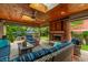 Cozy covered patio with wood ceiling, ceiling fan, fireplace, and outdoor kitchen with patio seating at 1320 N New Jersey St, Indianapolis, IN 46202