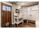 Bright laundry room with white cabinets and sink and a dark brown wooden door at 1320 N New Jersey St, Indianapolis, IN 46202