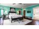 Bright main bedroom featuring a black bedframe, hardwood floors, and decorative artwork at 1320 N New Jersey St, Indianapolis, IN 46202