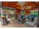 Comfortable outdoor living space features a ceiling fan, brick walls, an outdoor kitchen, and fireplace at 1320 N New Jersey St, Indianapolis, IN 46202