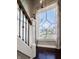 Staircase with white trim and iron spindles featuring a large window with a detailed design at 1320 N New Jersey St, Indianapolis, IN 46202