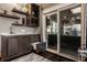 View of a bedroom wet bar with floating shelves, cabinet space, and a sliding door leading to a covered patio at 1320 N New Jersey St, Indianapolis, IN 46202