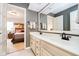 Bright bathroom featuring double sinks and an open doorway to a bedroom with neutral paint at 13661 Smokey Ridge Pl, Carmel, IN 46033