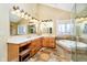 A full bathroom offering a double sink, tiled flooring, and a tub with a glass door shower at 13661 Smokey Ridge Pl, Carmel, IN 46033