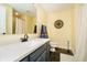 Bathroom featuring a blue vanity, speckled countertop, decorative mirror, and a tiled shower at 13661 Smokey Ridge Pl, Carmel, IN 46033