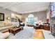 Bright living room features a fireplace, hardwood floors, large windows, and beamed ceilings at 13661 Smokey Ridge Pl, Carmel, IN 46033