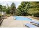 Inviting backyard pool surrounded by a concrete patio, beautiful landscaping, and mature trees at 13661 Smokey Ridge Pl, Carmel, IN 46033