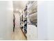 A walk-in closet with built-in shelves, hanging clothes, and clear-door cabinetry at 13661 Smokey Ridge Pl, Carmel, IN 46033