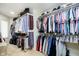 This walk-in closet is full of organized hanging clothes, and shelves stacked with purses at 13661 Smokey Ridge Pl, Carmel, IN 46033