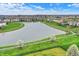 An aerial view of a serene pond surrounded by lush greenery in a residential community at 14242 Brandt Ln, Carmel, IN 46074