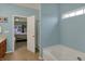 Light blue bathroom with an open door to the bedroom, a soaking tub, and a walk-in shower at 14242 Brandt Ln, Carmel, IN 46074