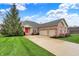 Beautiful brick home with attached two-car garage, lush green lawn, and inviting red front door at 14242 Brandt Ln, Carmel, IN 46074