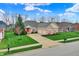A well-kept house featuring a brick facade and a two-car garage against a backdrop of mature trees and a green lawn at 14242 Brandt Ln, Carmel, IN 46074