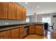 Kitchen with wood cabinets and floors, featuring a stainless steel dishwasher and dark countertops at 14242 Brandt Ln, Carmel, IN 46074