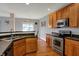 Kitchen features stainless steel appliances, warm wood cabinets, and hardwood floors at 14242 Brandt Ln, Carmel, IN 46074