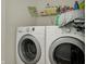 Laundry room featuring a white washer and dryer with storage shelves above at 14242 Brandt Ln, Carmel, IN 46074
