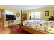 Bedroom featuring a four poster bed, yellow walls, wood floors and built in display case at 15247 E 191St St, Noblesville, IN 46060