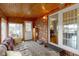 Bright sunroom featuring a neutral color palette, exposed brick, and an entrance to the home's main living area at 15247 E 191St St, Noblesville, IN 46060