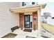 Cozy front porch with brick accents, small bench and manicured plants at 15281 Proud Truth Dr, Noblesville, IN 46060