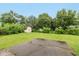 Large backyard with mature trees, shed, and paved patio area at 1612 Westbay Ct, Indianapolis, IN 46260