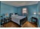Bright bedroom featuring hardwood floors, blue walls, and a window with natural light at 1612 Westbay Ct, Indianapolis, IN 46260