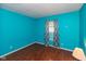 Bright bedroom with blue walls, wood floors, and patterned curtains at 1612 Westbay Ct, Indianapolis, IN 46260