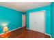 Bright bedroom features vibrant blue walls and hardwood floors, complemented by a spacious closet at 1612 Westbay Ct, Indianapolis, IN 46260