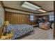 Bedroom with wood-paneled walls, tiled floor, and comfortable sleeping and sitting areas at 1612 Westbay Ct, Indianapolis, IN 46260