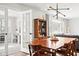 Bright dining room featuring hardwood table and floors with modern light fixture, flows into living room and separate office at 1621 Nottingham Dr, Indianapolis, IN 46240