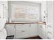 Charming kitchen nook featuring custom white cabinets, butcher block countertop, and ample natural light at 1621 Nottingham Dr, Indianapolis, IN 46240