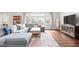 Cozy living room with hardwood floors, a comfortable gray sectional, and a view of the outdoors through large windows at 1621 Nottingham Dr, Indianapolis, IN 46240