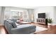 Bright living room with hardwood floors, a gray sectional sofa, and large windows for an open and inviting feel at 1621 Nottingham Dr, Indianapolis, IN 46240