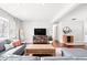 Bright living room with hardwood floors, a gray sectional sofa, and a large window providing natural light at 1621 Nottingham Dr, Indianapolis, IN 46240