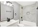 Bathroom with single sink vanity, modern fixtures, decorative mirror, and bathtub with marble tile surround at 1842 Tallman Ave, Indianapolis, IN 46218