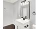 Bathroom features a white single sink vanity, modern fixtures, and a large, decorative mirror at 1842 Tallman Ave, Indianapolis, IN 46218
