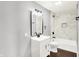 Bright bathroom featuring a single sink vanity, sleek fixtures, and a shower-tub combo with marble tile at 1842 Tallman Ave, Indianapolis, IN 46218