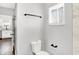 Bathroom with white toilet and towel rack. View through doorway to kitchen with white cabinetry at 1842 Tallman Ave, Indianapolis, IN 46218