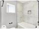 Corner of bright bathroom shows toilet, window with blinds, and marble-tiled shower at 1842 Tallman Ave, Indianapolis, IN 46218