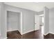 Bedroom with hardwood floors, light gray walls, closet and view through doorway to window at 1842 Tallman Ave, Indianapolis, IN 46218