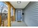 Charming front porch with wood columns, blue door, and gray wood-look siding at 1842 Tallman Ave, Indianapolis, IN 46218