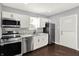 Updated kitchen with stainless steel appliances, granite countertops, and white cabinets and modern lighting at 1842 Tallman Ave, Indianapolis, IN 46218