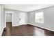 Light-filled living room featuring hardwood floors, gray walls, a front window, and a white door at 1842 Tallman Ave, Indianapolis, IN 46218