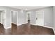 Spacious living room featuring hardwood floors and freshly painted gray walls, with three entry ways at 1842 Tallman Ave, Indianapolis, IN 46218