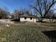Large backyard with a detached garage, visible peeling paint, and ample space for landscaping at 2503 S Lyons Ave, Indianapolis, IN 46241