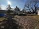 Backyard with a detached garage, covered with fallen leaves and visible neighbors at 2503 S Lyons Ave, Indianapolis, IN 46241