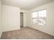 Bright bedroom with neutral carpet, closet, and large window overlooking the neighborhood at 3038 Wildcat Ln, Indianapolis, IN 46203
