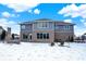 Back exterior of home featuring brick and siding, windows, and snow covered yard at 3283 Homestretch Dr, Carmel, IN 46032